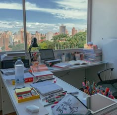 an office with a view of the city from it's window sill and desk