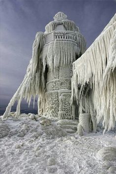 an ice covered fire hydrant with icicles on it's sides and the sky in the background