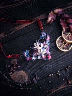 two pieces of fruit and flowers on a wooden table next to some dried oranges