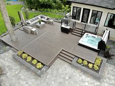 a hot tub sitting on top of a wooden deck next to a patio with seating