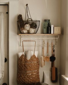 a basket and other items are hanging on a shelf above a toilet in a bathroom