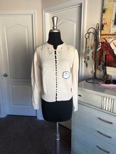 "<> 1980's cardigan <> Label: Dean's of Scotland <> Material: 55% silk 45% Cotton <> Color: Cream <> Button front <> Floral accents on the neckline <> Tags still attached $102.00 <> Condition: new with the tags, but it is missing the top button Measurements: Length: 20\" Bust: 36\" Waist: 34 Shoulders: 16\" Sleeves: 23\"" Vintage Spring Sweater With Buttons, Vintage Embroidered Cream Cardigan, Vintage Cream Embroidered Cardigan, Vintage Fitted Sweater For Spring, Vintage Cream Sweater For Spring, Vintage Long Sleeve Cardigan With Buttons, Vintage Winter Sweater For Daywear, Vintage Button-up Spring Sweater, Vintage Embroidered Fall Sweater