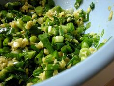 green vegetables are mixed together in a bowl