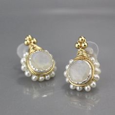 "Gleaming and romantic stud earrings made of 14K gold filled and silver bezel, set with beautiful shiny 10mm rainbow moonstone gemstone, encircled by delicate freshwater pearls. Moonstone earrings would be essential part for elegant and stunning look, especially for weddings and engagement parties. They come with silicone backs, for your comfort and security. The post is made of gold filled. The earring's post can be made with sterling silver or solid gold incase of allergy issues. Please choose Delicate Moonstone Earrings For Wedding, Delicate Moonstone Wedding Earrings, Handmade Moonstone Earrings For Wedding, Handmade Moonstone Wedding Earrings, White Gemstone Round Bridal Earrings, White Moonstone Birthstone Earrings, Delicate White Moonstone Earrings, Gold Pearl Gemstone Earrings For Anniversary, Elegant Moonstone Wire Wrapped Earrings