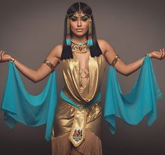 an egyptian woman dressed in gold and blue with her arms spread out to the side