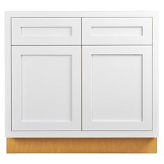 a white cabinet with two doors and one drawer on the top, in front of a wooden