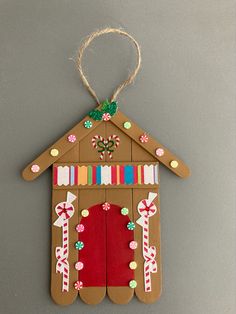 a gingerbread house ornament hanging on a wall