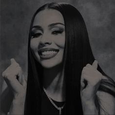 a black and white photo of a woman with long dark hair holding her hands in the air