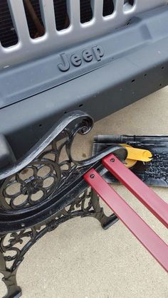 a pair of pliers are laying on the ground next to a bench that has been painted black