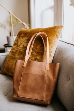 Handcrafted hand-stitched leather tote. Options for flat handles with silver or copper rivets, or roped (rounded) handles with rivets or stitching. Please let us know in the comments what you would like. The primary color is leather color. Flat handled standard totes are $200, roped handled deluxe bags are $275, addition of an exterior pocket to any bag is an additional $50.  IF YOU WOULD LIKE A CROSSBODY BAG, PLEASE CONTACT ME DIRECTLY FOR PAYMENT. We are a husband and wife team located in Bend, OR. We started leather working as a hobby, and enjoy making 100% handcrafted goods for our customers. No sewing machine here. Curious about our other products? Visit our social media pages @jamesleatherco, or our website: jamesleatherco.com Diy Leather Tote Bag, Diy Leather Tote, Handmade Leather Tote Bag, Handmade Leather Purse, Leather Totes, Leather Card Wallet, Leather Artisan, Brown Leather Totes, Large Leather Tote