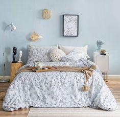 a bedroom with blue walls and white bedding in the center is decorated with wicker decorations