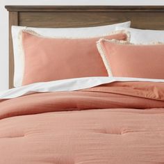 an orange comforter and pillows on a bed