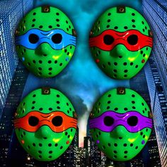 four green masks with black dots on them in front of a cityscape at night