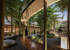 the inside of a building with plants and rocks on the ground near stairs leading up to it