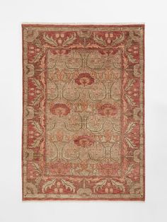 an antique rug with red and beige colors