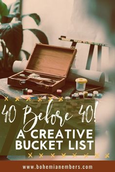 an open suitcase sitting on top of a table next to paint brushes and other items