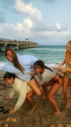 four girls and two boys are posing on the beach