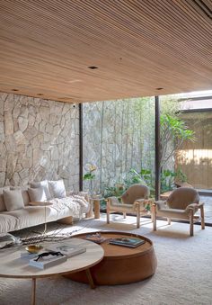 a living room filled with furniture next to a wall covered in stone and wood planks