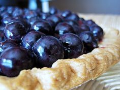 a close up of a pie with blueberries on it