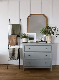 a dresser and mirror in a room with white walls