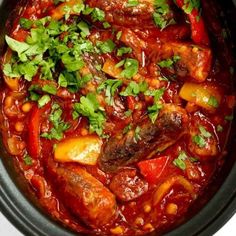 a close up of a stew in a crock pot with garnishes