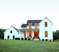 a large white house sitting on top of a lush green field