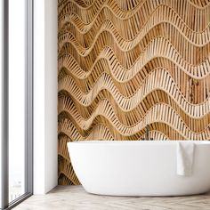 a white bath tub sitting in front of a window next to a wall with waves on it