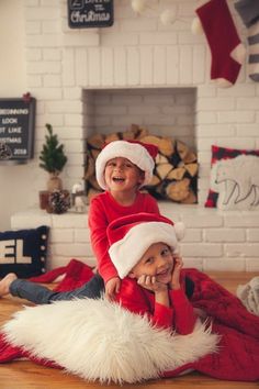 two children in santa hats sitting on the floor