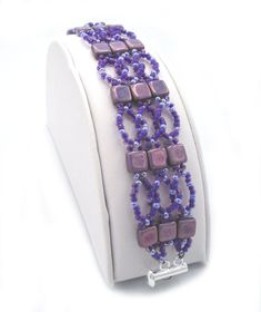 a bracelet with purple beads is on display