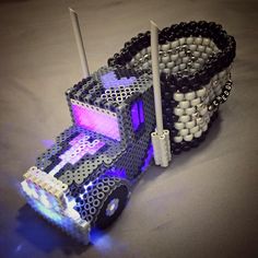 a toy truck made out of legos with lights on it's tires and wheels