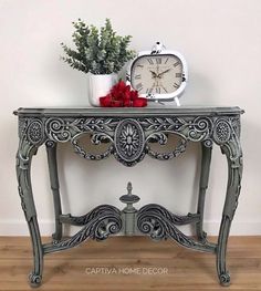 an ornate console table with a clock and potted plant on top, against a white wall