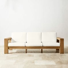 a white couch sitting on top of a tiled floor