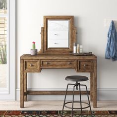 a wooden dressing table with mirror and stool