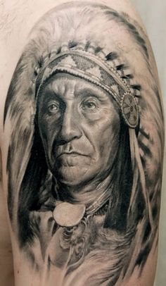 a man with a native american headdress tattoo on his arm