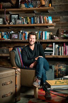 a man sitting in a chair next to a bookshelf