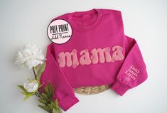 Boho Mama Puff Print Sweatshirt, Embossed Mama Sweatshirt with Names, Flower Mama Sweatshirt, Puff Mom Sweatshirt, Mother's Day Gift This super soft sweatshirt can be custom printed with or without names on the sleeve.  The print is embossed puff print.  See color options in the photos.  The sweatshirt in main photo is the color heliconia with print puff print. ITEM DETAILS * Crewneck Sweater, 50% cotton, 50% polyester * Unisex Sizing: S, M, L, XL, 2XL * T-Shirt, depending on color, either 100% Mother's Day Pink Cotton Sweatshirt, Pink Cotton Sweatshirt For Mother's Day, Boho Mama, Htv Shirts, Liquid Fabric, Flower Sweatshirt, Puff Print, Personalized Gifts For Mom, Mama Sweatshirt