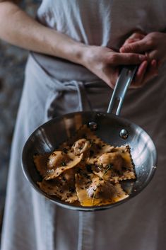 a person holding a pan with some food in it