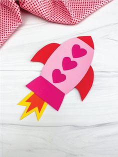 a paper rocket with hearts on it