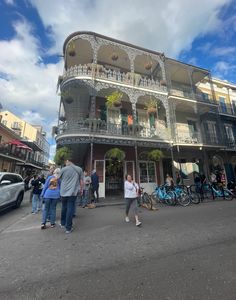 people are walking around in front of a building with balconies and balconyes