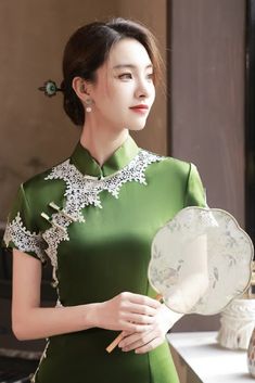 This chic long green cheongsam dress is the latest addition to the modern collection. It perfectly combines classic elements like the high mandarin collar, lace details, and knotted Chinese buttons with a contemporary design. Modern Qipao Dress, Qipao Wedding, Vietnam Dress, Modern Qipao, Qipao Dress, Old Fashion Dresses, Cheongsam Dress, Exotic Fashion, Chinese Dress