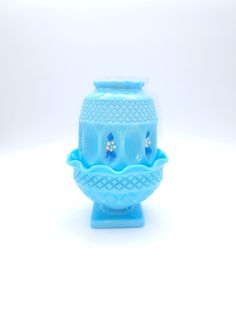 a blue vase sitting on top of a white table