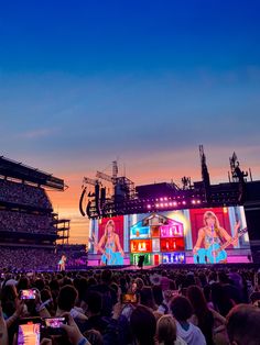 a large crowd is watching a concert on the big screen in front of an audience