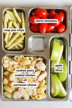 an open lunch box with pasta, tomatoes, and other food items in it that include apples, cherry tomatoes, cheesy potatoes