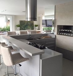 a modern kitchen with stainless steel appliances and bar stools next to the countertop