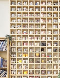 the shelves are filled with many different kinds of coffee mugs and teacups