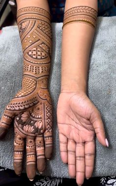 two hands with henna tattoos on them