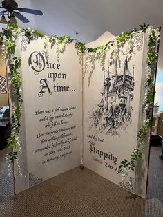 an open room divider decorated with paper cutouts and greenery on the sides