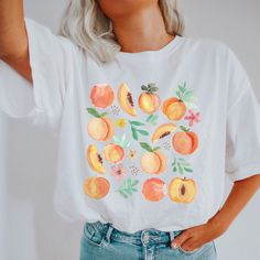 botanical shirt | fairycore apparel | fairycore shirt | fruit drawing tshirt | fresh peaches shirt | cottage core shirt | summer peach shirt This Bella T-shirt is light-weight with just the right amount of stretch. Perfect for wearing on its own or layering with a jacket or cardigan - this Tee is comfortable, soft, and durable. * 100% combed and ring-spun cotton * Fabric weight: 4.2 oz (142 g/m2) * Pre-shrunk fabric * Side-seamed construction * Shoulder-to-shoulder taping * We do not accept returns or exchanges. However, if you experience an issue with them item received, please message the shop Woah there! It looks like you've gone a little too far - don't like this tshirt? No problem, we won't take it personally 😉 You can check out some of our other great designs back at our shop here: Peach Themed Outfit, Casual Peach Summer Shirt, Peach Short Sleeve Shirt For Summer, Summer Peach Cotton Shirt, Peach Cotton Summer Shirt, Peach Cotton Tops For Brunch, Cottagecore Printed Summer T-shirt, White Cottagecore T-shirt For Summer, Summer Cottagecore Shirt With Relaxed Fit