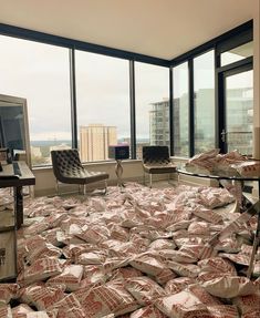 a pile of bags sitting on top of a bed next to a large glass window