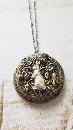 Rabbit Locket Wanderlust Necklace  Beautifully detailed Locket with cute little bunny against nature scene. Can be used to store your treasured photo or as small a pill box.  ☻ See Photos for size comparison against American quarter Chain: ~ Antique Silver  YOU CHOOSE YOUR CHAIN LENGTH during checkout ☻More Lockets Here: https://www.etsy.com/shop/FashionCrashJewelry/search?search_query=lockets&order=date_desc&view_type=gallery&ref=shop_search ☻Link to The ENTIRE SHOP: https://www.etsy.com/shop/FashionCrashJewelry?ref=shopsection_shophome_leftnav&ga_search_query=crystal%2Bnecklace Our Motto ~ Happy Customers Are Awesome Let us know of any problems or concerns with purchases. 5star reviews and positive comments are greatly appreciated, they help the success of our shop more than you know ♥ T Wanderlust Necklace, Rabbit Necklace, Enchanting Forest, Wanderlust Jewelry, Rabbit Necklaces, Vintage Jewlery, Jewelry Nature, Nature Necklace, Steampunk Accessories